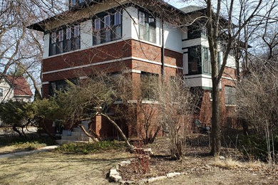 Photo of a large arts and crafts two-storey stucco beige house exterior in Chicago with a hip roof and a shingle roof.