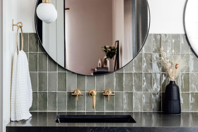 ソルトレイクシティにあるミッドセンチュリースタイルのおしゃれな浴室 (中間色木目調キャビネット、緑のタイル、黒い洗面カウンター、洗面台2つ、フローティング洗面台) の写真