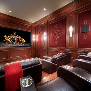 Inspiration for a timeless enclosed medium tone wood floor home theater remodel in Montreal with brown walls and a projector screen