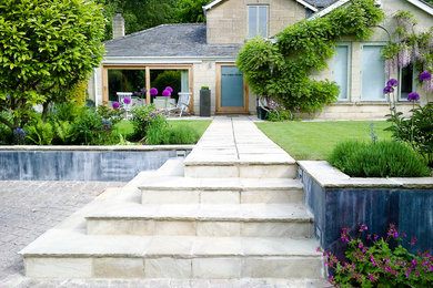 Mid-sized contemporary backyard full sun garden in Other with natural stone pavers for summer.