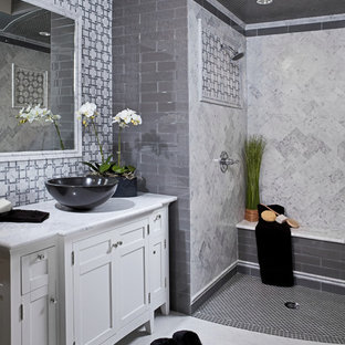 Immagine di una stanza da bagno moderna con top in marmo, lavabo a bacinella e piastrelle di marmo