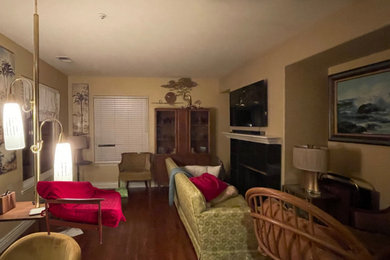 オレンジカウンティにあるお手頃価格の中くらいなミッドセンチュリースタイルのおしゃれなLDK (黄色い壁、ラミネートの床、標準型暖炉、タイルの暖炉まわり、壁掛け型テレビ、茶色い床) の写真