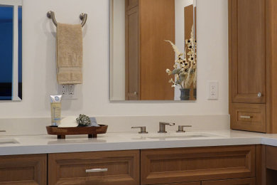 Inspiration for a transitional bathroom remodel in Orange County with brown cabinets, an integrated sink and quartz countertops