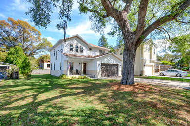 Mid-sized contemporary beige two-story stucco house exterior idea in Tampa with a hip roof and a shingle roof