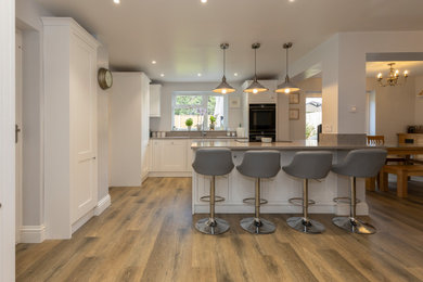 Photo of a contemporary open plan kitchen in Other with white cabinets, quartz worktops, an island and grey worktops.