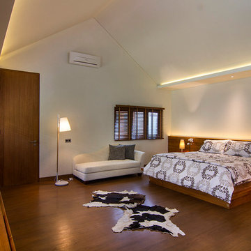 spacious bedroom with dominant teak floor and furniture