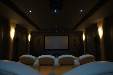 Example of a large minimalist enclosed home theater design in Toronto with beige walls and a projector screen