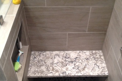 This is an example of a small transitional 3/4 bathroom in Other with an undermount sink, shaker cabinets, white cabinets, engineered quartz benchtops, gray tile, porcelain tile, grey walls and pebble tile floors.