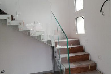 Idee per un'ampia scala moderna con parapetto in vetro