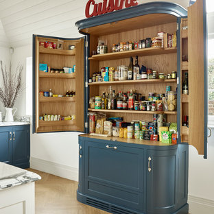 Farmhouse kitchen pantry photos - Example of a country light wood floor kitchen pantry design in Kent with recessed-panel cabinets and blue cabinets
