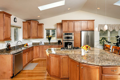 Inspiration for a large transitional l-shaped medium tone wood floor eat-in kitchen remodel in Baltimore with an undermount sink, recessed-panel cabinets, medium tone wood cabinets, stainless steel appliances, granite countertops and an island