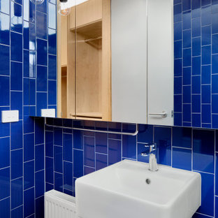 Inspiration for a small contemporary master bathroom in Melbourne with an open shower, blue tile, ceramic tile, blue walls, ceramic floors, a wall-mount sink, grey floor, an open shower, a single vanity and a floating vanity.