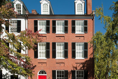 Large modern red three-story brick house exterior idea in DC Metro