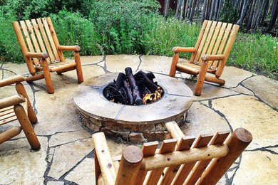 Mid-sized mountain style backyard stone patio photo in Denver with a fire pit