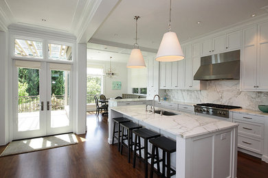 Inspiration for a large contemporary l-shaped dark wood floor open concept kitchen remodel in Seattle with an undermount sink, white cabinets, stainless steel appliances, an island, shaker cabinets, marble countertops, multicolored backsplash and stone slab backsplash