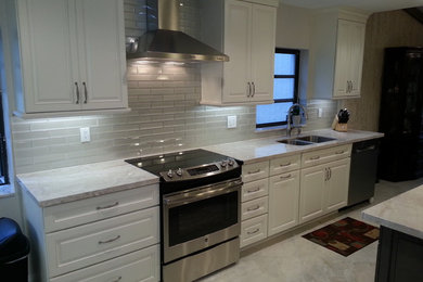 Inspiration for a mid-sized transitional l-shaped eat-in kitchen in Miami with an undermount sink, raised-panel cabinets, white cabinets, quartzite benchtops, beige splashback, glass tile splashback, stainless steel appliances and with island.