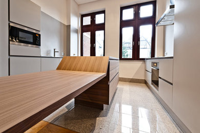 Offene, Zweizeilige, Mittelgroße Moderne Küche mit integriertem Waschbecken, flächenbündigen Schrankfronten, grauen Schränken, Edelstahl-Arbeitsplatte, Küchengeräten aus Edelstahl, Marmorboden und Kücheninsel in Frankfurt am Main