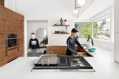 Eat-in kitchen - small 1960s u-shaped terrazzo floor and black floor eat-in kitchen idea in Portland with an undermount sink, flat-panel cabinets, dark wood cabinets, quartz countertops, white backsplash, ceramic backsplash, paneled appliances and white countertops