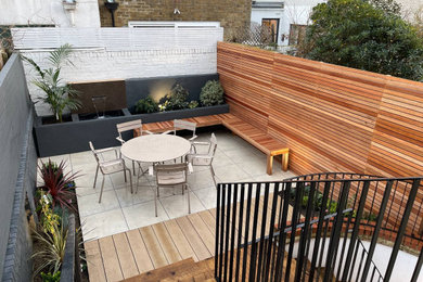 Inspiration for a medium sized modern courtyard ground level metal railing terrace in London with fencing.
