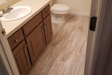 Inspiration for a 3/4 beige floor and single-sink bathroom remodel in Atlanta with raised-panel cabinets, brown cabinets, a one-piece toilet, beige walls, beige countertops and a built-in vanity