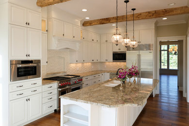Large cottage chic l-shaped dark wood floor and brown floor eat-in kitchen photo in Other with an undermount sink, raised-panel cabinets, white cabinets, granite countertops, white backsplash, stainless steel appliances and an island