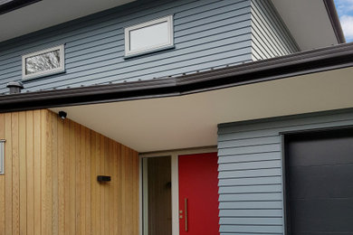 Inspiration for a contemporary two-storey house exterior in Christchurch with mixed siding, a metal roof and a black roof.