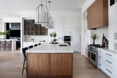 Large beach style eat-in kitchen photo in Other with white cabinets, marble countertops, white backsplash, marble backsplash, an island and white countertops
