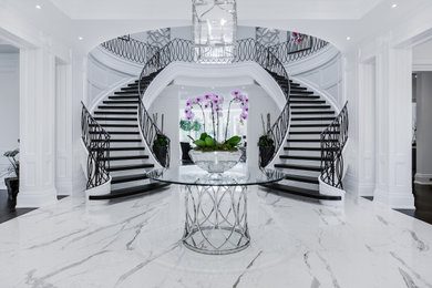Example of a large classic wooden curved open and metal railing staircase design in Toronto