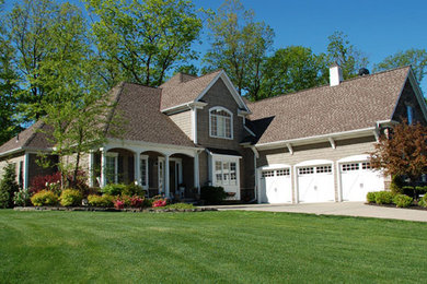 Large elegant gray two-story stone exterior home photo in Cleveland with a shingle roof