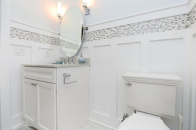 Small beach style black and white tile wood-look tile floor and gray floor powder room photo in Philadelphia with recessed-panel cabinets, white cabinets, blue walls and a built-in vanity