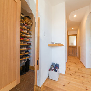 他の地域のアジアンスタイルのおしゃれなマッドルーム (白い壁、茶色い床) の写真