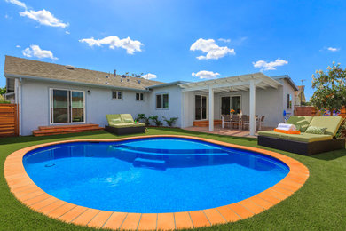 Mid-sized transitional backyard brick and custom-shaped pool photo in Orange County