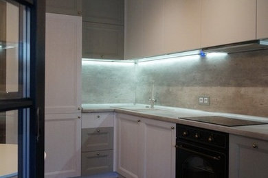 Idéer för ett mellanstort modernt kök, med en enkel diskho, luckor med infälld panel, vita skåp, bänkskiva i betong, grått stänkskydd, stänkskydd i cementkakel, svarta vitvaror, vinylgolv och brunt golv