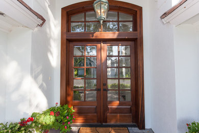 Inspiration for a mid-sized mediterranean front door in Miami with beige walls, a double front door and a dark wood front door.