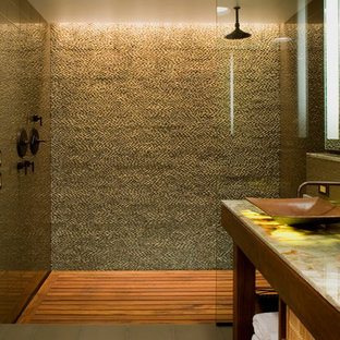 Aménagement d'une salle de bain montagne avec un plan de toilette en onyx et un carrelage en pâte de verre.