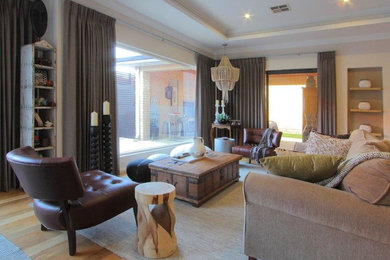 This is an example of a large transitional open concept living room in Perth with beige walls and light hardwood floors.