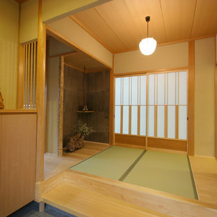 Неиссякаемый источник вдохновения для домашнего уюта: узкая прихожая среднего размера в восточном стиле с татами, бежевыми стенами, раздвижной входной дверью, входной дверью из дерева среднего тона и коричневым полом