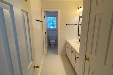 Mid-sized elegant kids' white tile and ceramic tile porcelain tile, white floor and double-sink bathroom photo in Atlanta with raised-panel cabinets, white cabinets, a two-piece toilet, white walls, solid surface countertops, white countertops and a built-in vanity