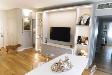 Foto di un soggiorno design di medie dimensioni e chiuso con libreria, pareti bianche, parquet chiaro e TV a parete
