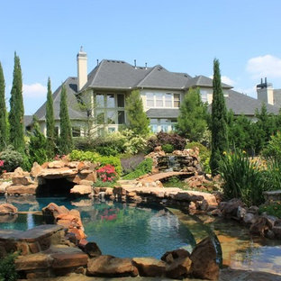 ダラスの円形ラスティックスタイルのおしゃれな裏庭プール (天然石敷き) の写真