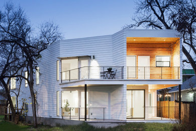 Imagen de fachada de casa blanca actual grande de dos plantas con tejado plano y tablilla