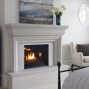 This is an example of a small beach style bedroom in Vancouver with white walls, carpet, a standard fireplace and a concrete fireplace surround.