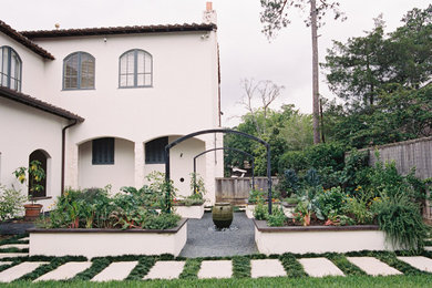 Diseño de jardín mediterráneo grande en patio trasero con jardín francés, macetero elevado, exposición total al sol y adoquines de piedra natural