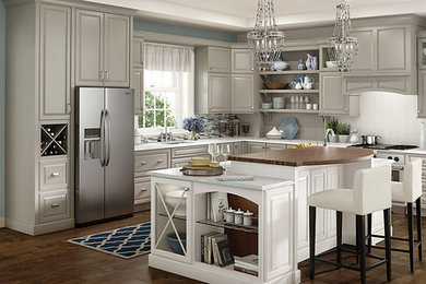 Eat-in kitchen - large traditional l-shaped medium tone wood floor eat-in kitchen idea in Nashville with an undermount sink, raised-panel cabinets, gray cabinets, quartzite countertops, white backsplash, glass tile backsplash, stainless steel appliances and two islands