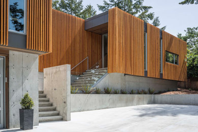 Large modern two-story wood exterior home idea in Other with a mixed material roof