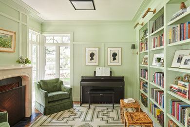 Abgetrenntes Klassisches Musikzimmer mit grüner Wandfarbe, braunem Holzboden, Kamin und Kaminumrandung aus Stein in Austin