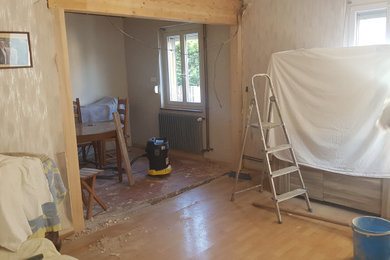 Exemple d'une salle à manger ouverte sur le salon chic avec un mur bleu, aucune cheminée, un manteau de cheminée en brique, un plafond en bois et du papier peint.