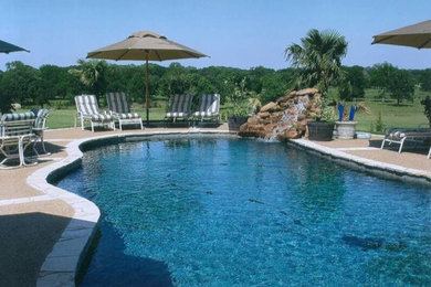Pool fountain - mid-sized traditional backyard custom-shaped pool fountain idea in Dallas