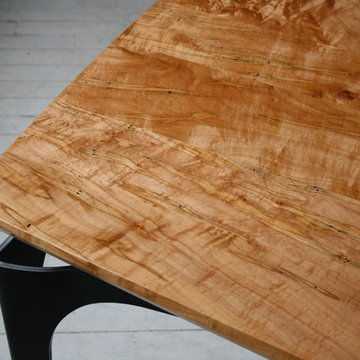 Bowed Stiletto Dining Table shown in Ambrosia Maple
