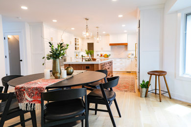 Example of a large transitional u-shaped light wood floor and brown floor eat-in kitchen design in Chicago with an undermount sink, shaker cabinets, white cabinets, quartz countertops, white backsplash, quartz backsplash, paneled appliances, an island and white countertops